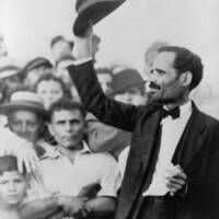 Pedro Albizu Campos raising his hat to a crowd